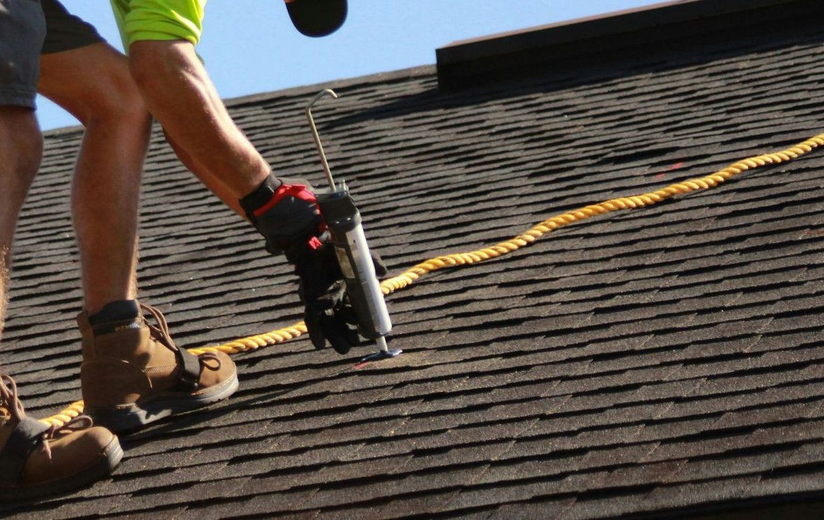 a man working on a roof with a power drill